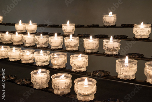 Brennende Kerzen aufgereiht auf Metallgestell, seitlich