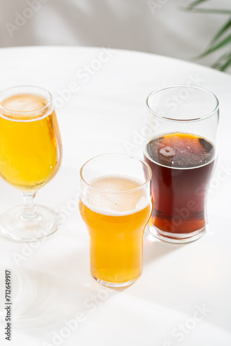 glasses with light beer and dark ale cider on white table