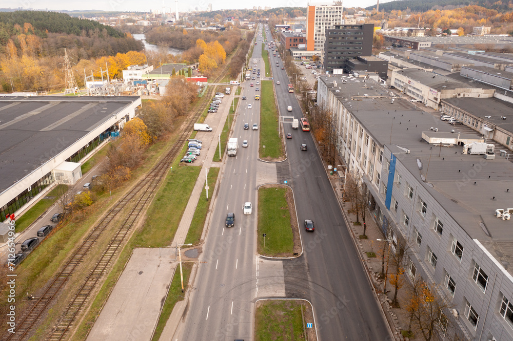 Drone photography of industrial part of town and high intensity road with traffic during autumn day