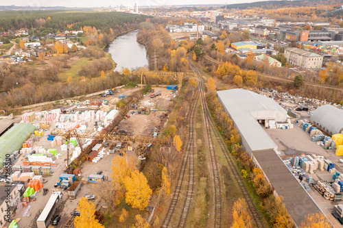 Drone photography of railway going to industrial park in a city during autumn day