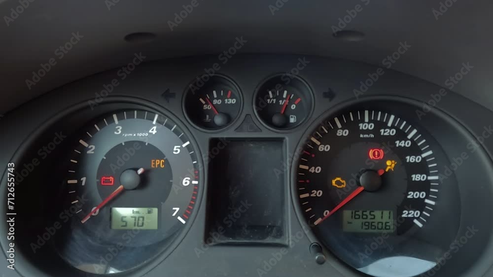 image of a car instrument panel, showing various gauges and warning