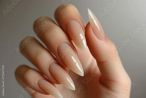 Elegance in every detail  Capture the beauty of a nude shades nail polish manicure on a woman s hand at a luxury salon. Exquisite nail art with gel polish for a sophisticated touch.