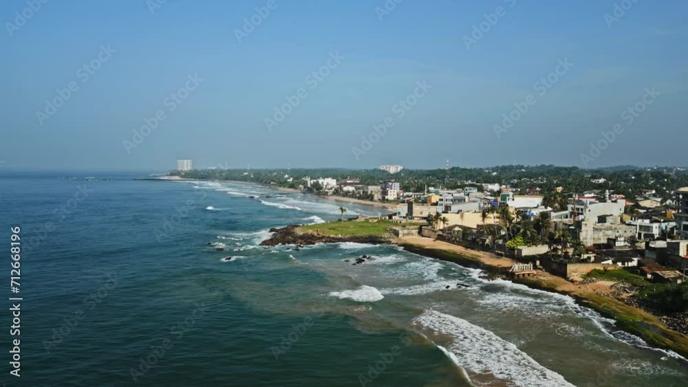 Aerial view of Galle Fort, coastline with beach, waves, historic landmarks in Sri Lanka. Drone footage showcases tourism, cultural heritage, tropical landscape, urban planning, scenic destinations. Aerial view of Galle Fort, coastline with beach, waves, historic landmarks in Sri Lanka. Drone footage showcases tourism, cultural heritage, tropical landscape, urban planning, scenic destinations.