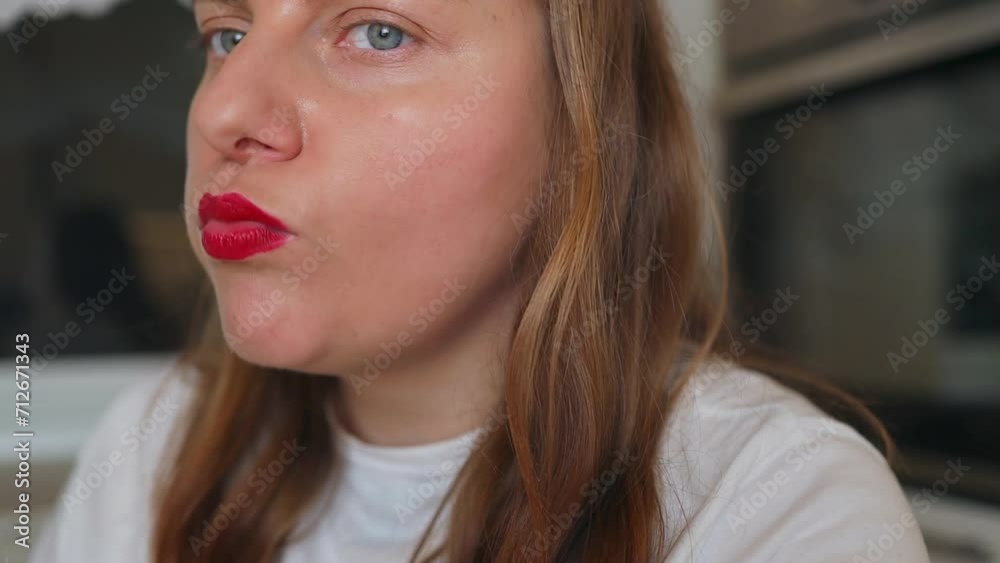 Cropped video of woman in white t-shirt with red lipstick smudge, eating fried chicken, nuggets at kitchen at cozy home. Cropped video of woman in white t-shirt with red lipstick smudge, eating fried chicken, nuggets at kitchen at cozy home.