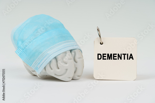 On a white surface next to the brain there is a notepad with the inscription - Dementia