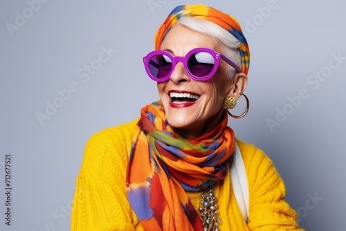 Portrait of a happy senior woman wearing sunglasses and colorful scarf.