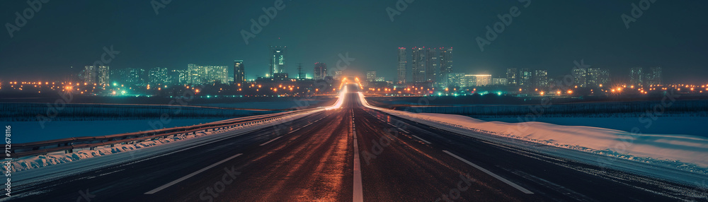 winter highway. city skyline at night. city lights. tall buildings and skyscrapers at night. dark winter night sky, snow covered sideways on a highway leading to the horizon. 