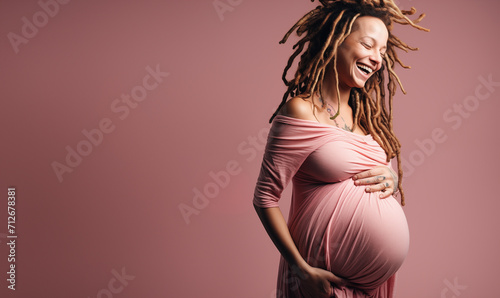 Belle femme métisse enceinte debout sur fond rose, image avec espace pour texte photo
