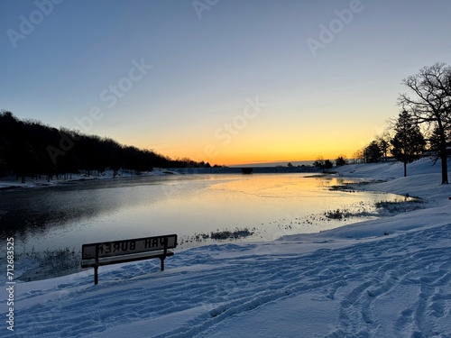 Sunrise at Van Buren Arkansas City Park Lake in the Winter with snow on the ground.