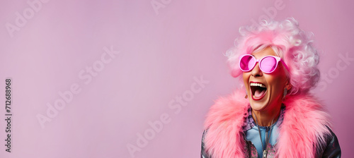 Happy laughing funny woman of old senior age, pink banner background with copy space