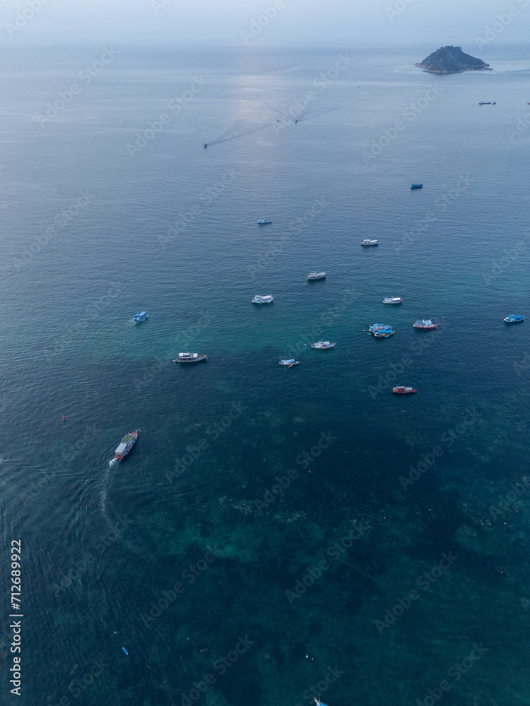 Bateau en pleine mer amarrés. Proche d'une île avec une eau turquoise. Vue du ciel et soleil couchant. Bateau en pleine mer amarrés. Proche d'une île avec une eau turquoise. Vue du ciel et soleil couchant.