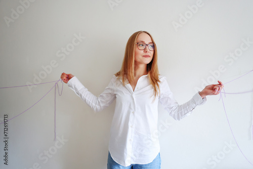 Beautiful woman wrapped in a rope over grey wall 