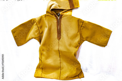 Traditional African clothing, Saharian berberian kachabia or qashabiya removable hood upper part warm sweater made of camel hair and wool in brownish color and brown threads. Isolated white background photo