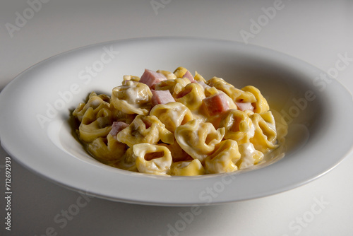 Soup bowl with tortellini pasta with cream and ham