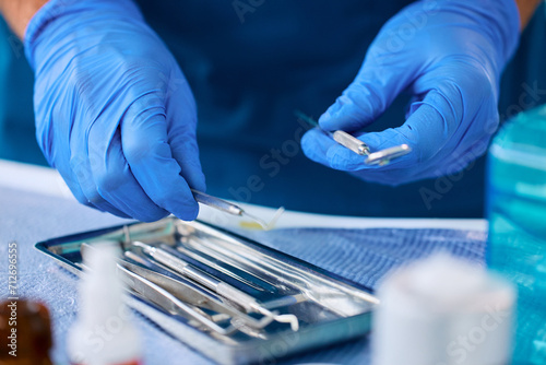 Close up of stomatologist preparing dental tools for teeth examination.