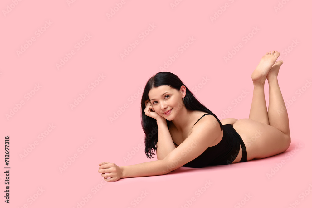 Body positive young woman in underwear lying on pink background Body positive young woman in underwear lying on pink background