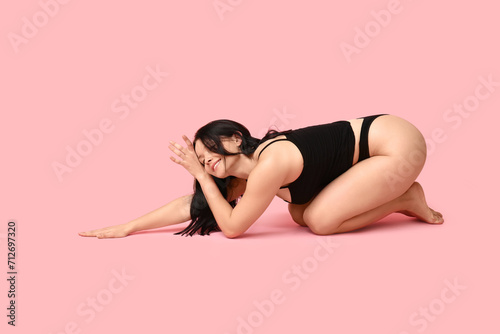 Body positive young woman on pink background