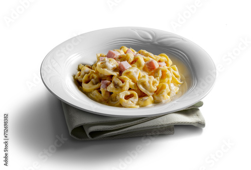 Tortellini soup bowl with cream and ham on white background