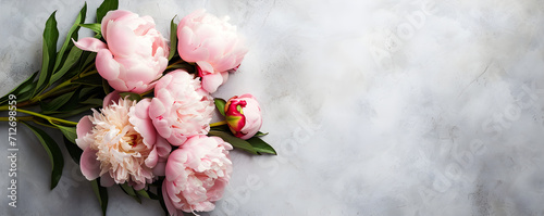 Flat lay banner with bunch of light pink peonies on marble background. Greeting card with copy space for spring, World Womens Day, March 8, Mothers day, Valentines Day, Birthday, Wedding.