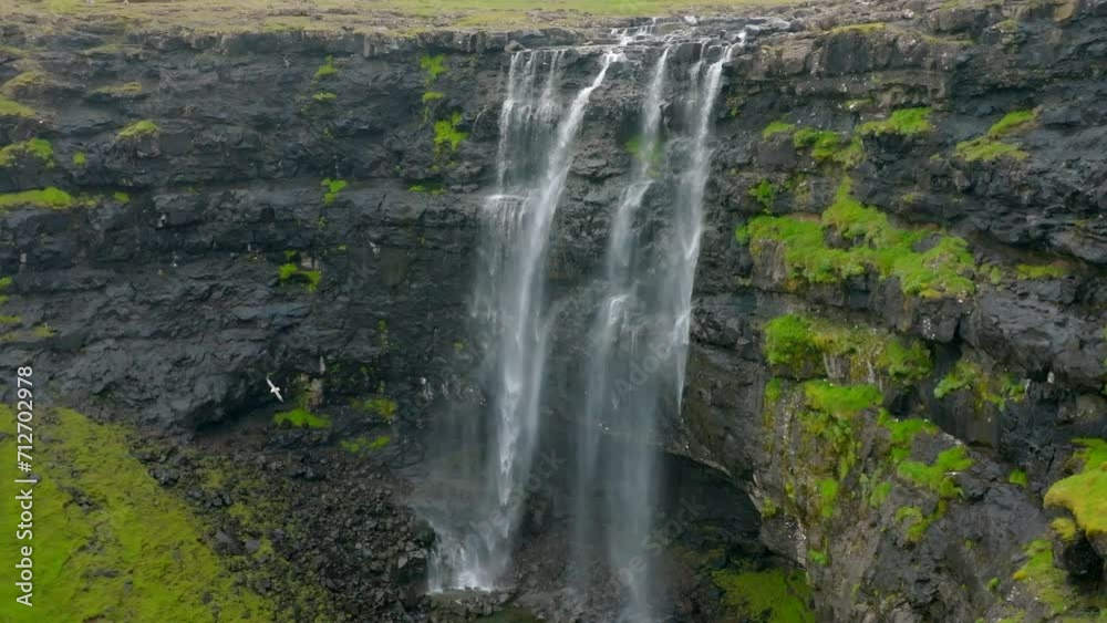 Aerial Backward Ascending Scenic View Of Water Flowing On Cliff Of Island - Faroe Islands, Denmark Aerial Backward Ascending Scenic View Of Water Flowing On Cliff Of Island - Faroe Islands, Denmark