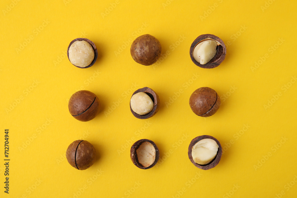 Tasty Macadamia nuts on yellow background, flat lay