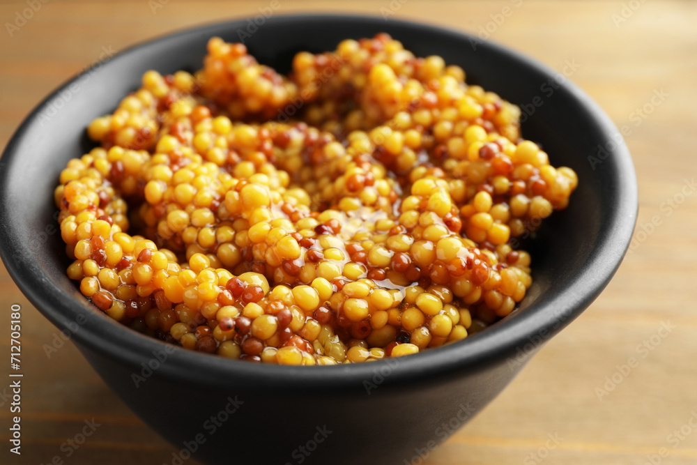 Fresh whole grain mustard in bowl on wooden table, closeup Fresh whole grain mustard in bowl on wooden table, closeup