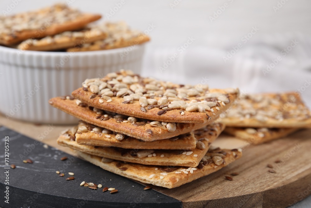 Cereal crackers with flax, sunflower and sesame seeds on board, closeup Cereal crackers with flax, sunflower and sesame seeds on board, closeup