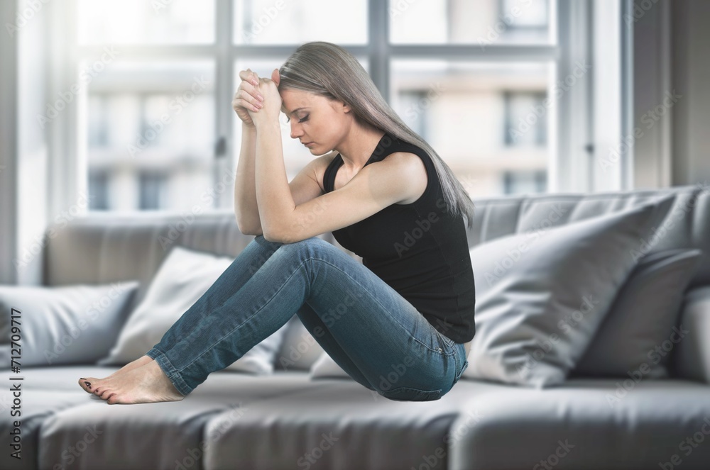 Obraz premium Young beautiful sad woman sitting crying at home