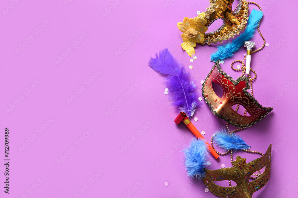 Carnival masks with party horns and feathers for Mardi Gras celebration on purple background