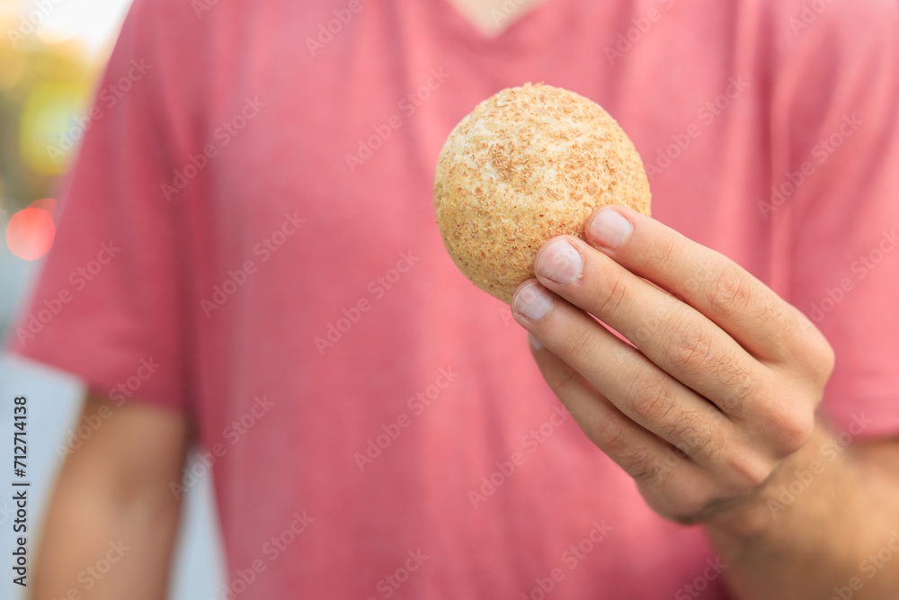 Guy's hand holds mini bread, snack and fast food concept. Selective focus on hands with blurred background Guy's hand holds mini bread, snack and fast food concept. Selective focus on hands with blurred background