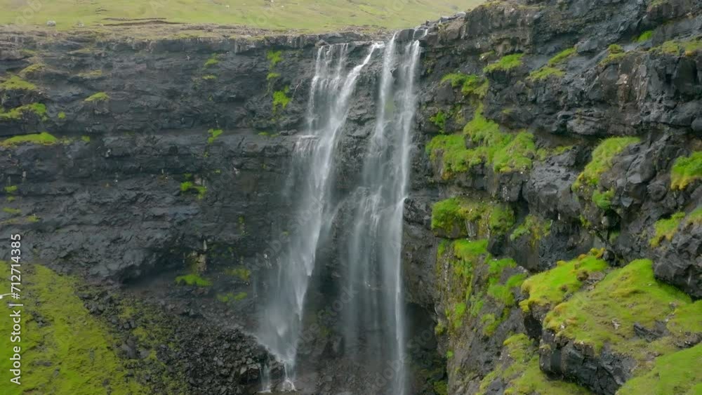 Aerial Forward Slow Motion Shot Of Birds Flying Towards Waterfall On Green Cliff - Faroe Islands, Denmark Aerial Forward Slow Motion Shot Of Birds Flying Towards Waterfall On Green Cliff - Faroe Islands, Denmark