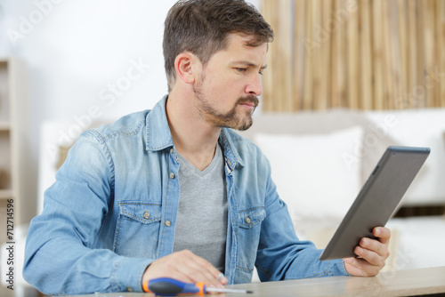 man checking app for assembly a furniture photo