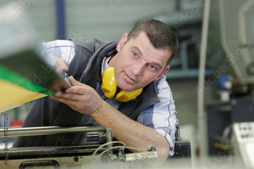 Tableau sur toile man worker working on tool machine in a factory