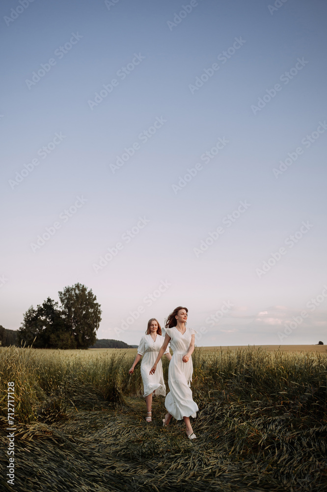 The image features two women wearing white dresses in an outdoor setting 5709. The image features two women wearing white dresses in an outdoor setting 5709.