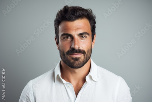 Portrait of handsome man with beard and mustache in white shirt.