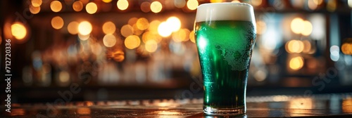 Green beer in pint glass on bar with bokeh lights. Banner, poster, header with copy space. Ireland and Irish holidays. St Patrick's Day celebration concept