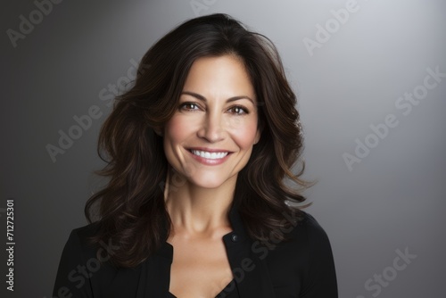 Portrait of a beautiful businesswoman smiling at the camera over grey background