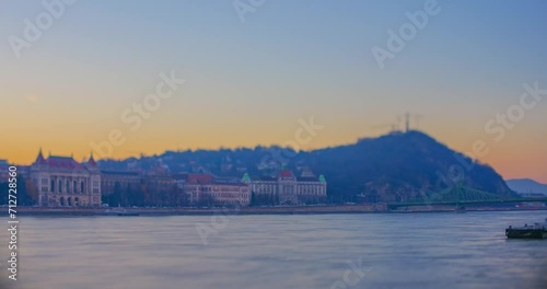 Hungary, Budapest - December 19, 2023: Technology university and liberty statue view from the opposite side of the Danube river. Focus tilted to the car traffic. Time-lapse video. photo