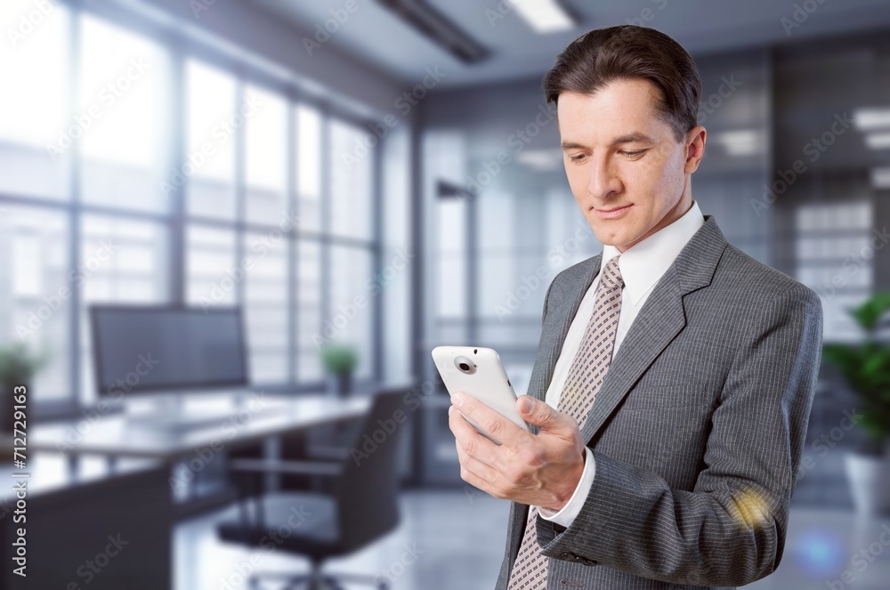 Smiling mature businessman holding modern smartphone Smiling mature businessman holding modern smartphone