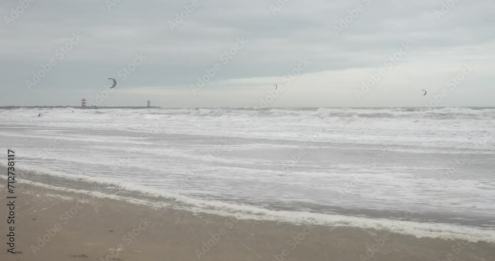Keizerstraat, 2586 ZZ Den Haag, Netherlands - December 23, 2023: North sea in winter. Surfers on the background. Keizerstraat, 2586 ZZ Den Haag, Netherlands - December 23, 2023: North sea in winter. Surfers on the background.