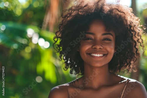 Beautiful young black woman with flawless skin and captivating smile looking at camera photo