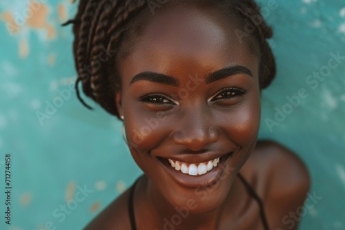 Beautiful young black woman with flawless skin and captivating smile looking at camera