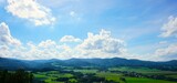 Panorama na góry i błękitne niebo. W otoczeniu gór widać liczne zabudowania.