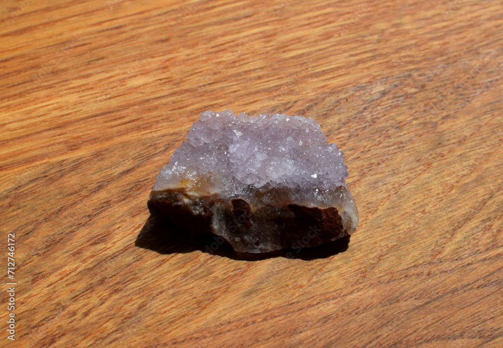 Beautiful lilac druse with amethyst crystals on a wooden background. Magical semi-precious stones. Beautiful lilac druse with amethyst crystals on a wooden background. Magical semi-precious stones.