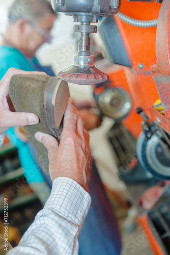 Fotografi a shoemaker adjusting a heel