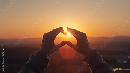 Heart from two hands on sunrise background, love romantic setting