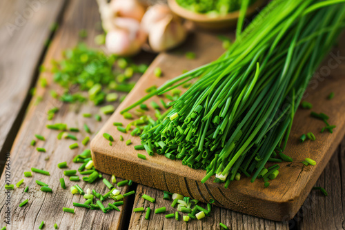 Bunch of fresh chives on a wooden cutting board, selective focus