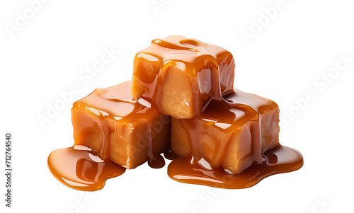 Sweet caramel candy cubes topped with caramel sauce on white background.