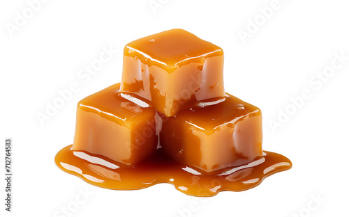 Sweet caramel candy cubes topped with caramel sauce on white background.