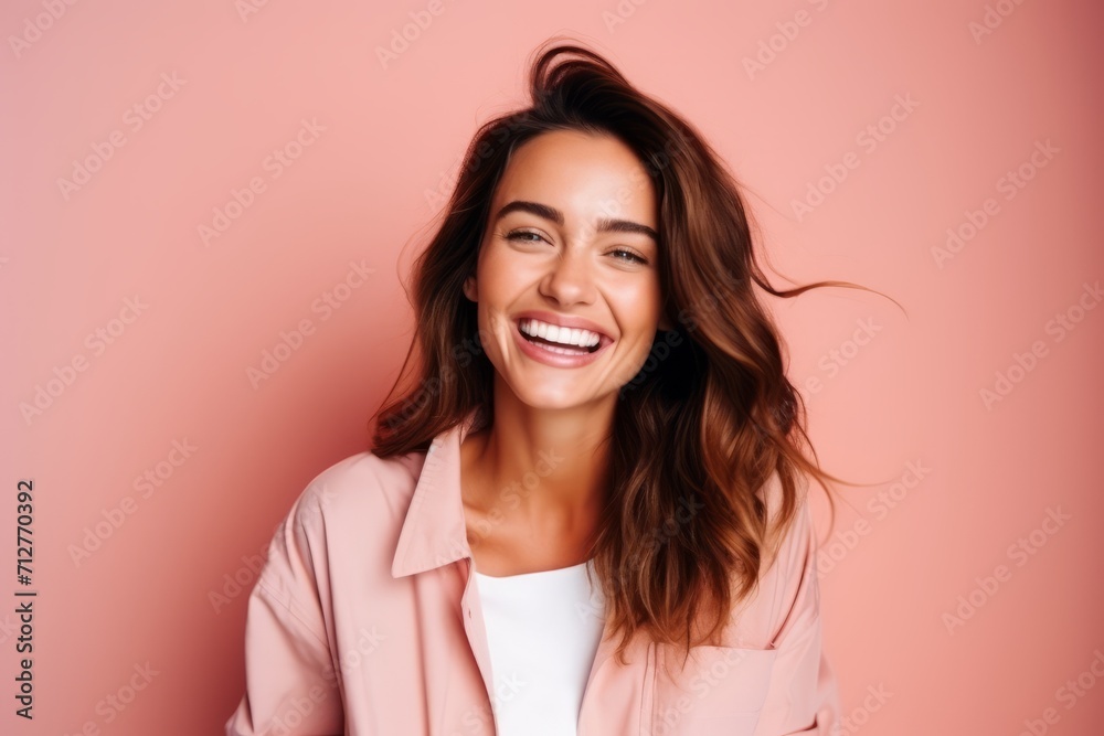 Portrait of a beautiful young woman laughing against a pink background. Portrait of a beautiful young woman laughing against a pink background.